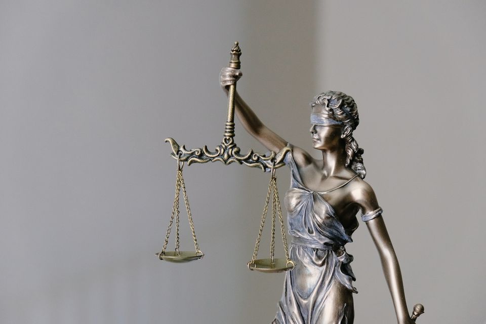 Statue of Lady Justice holding a set of scales and a sword, symbolizing impartiality and fairness in the legal system.