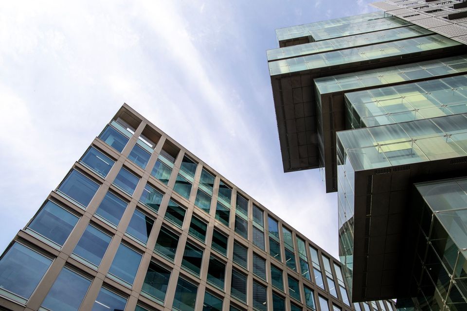 The image shows a brick building with arched windows and a sidewalk running alongside it.